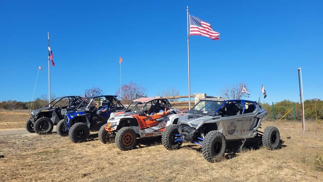 SxSWeRide machine with riders gathered on a trail